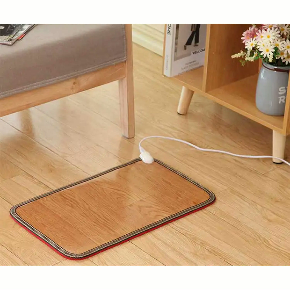 Tapis chauffant 50 x 30 cm effet bois posé sur un parquet, cordon et interrupteur visibles