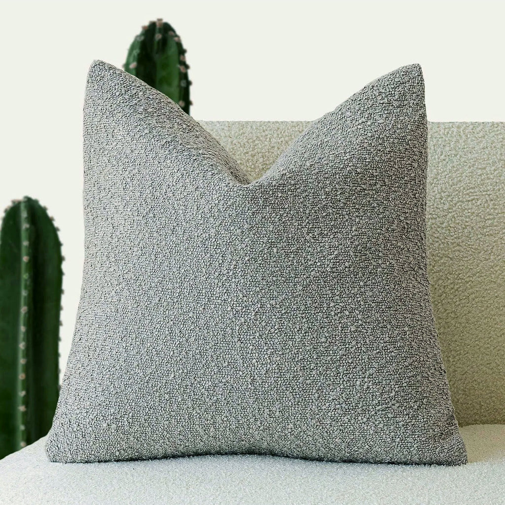 Housse de coussin bouclette gris clair de face sur un canapé