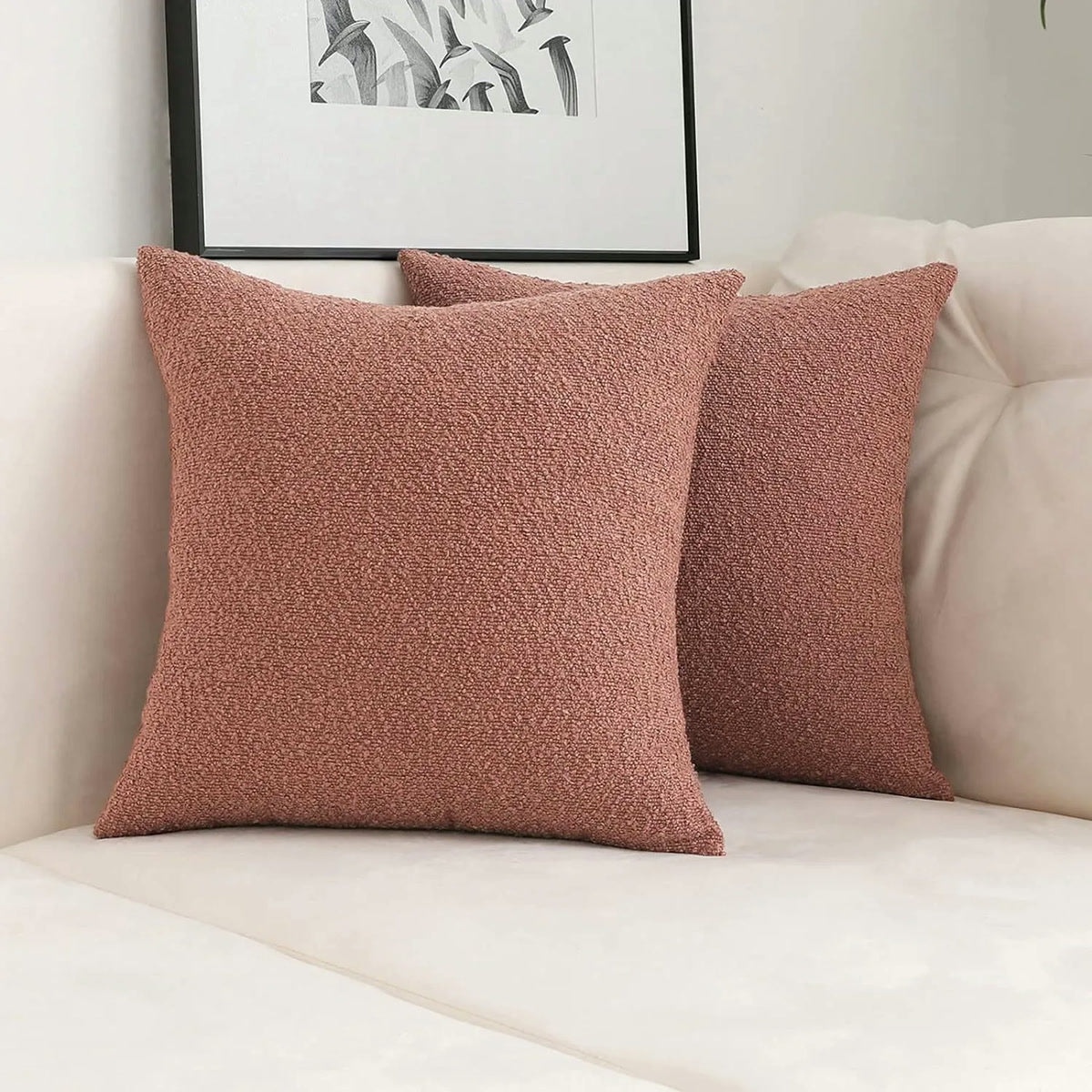 Deux housses de coussin bouclette terracotta sur un canapé blanc