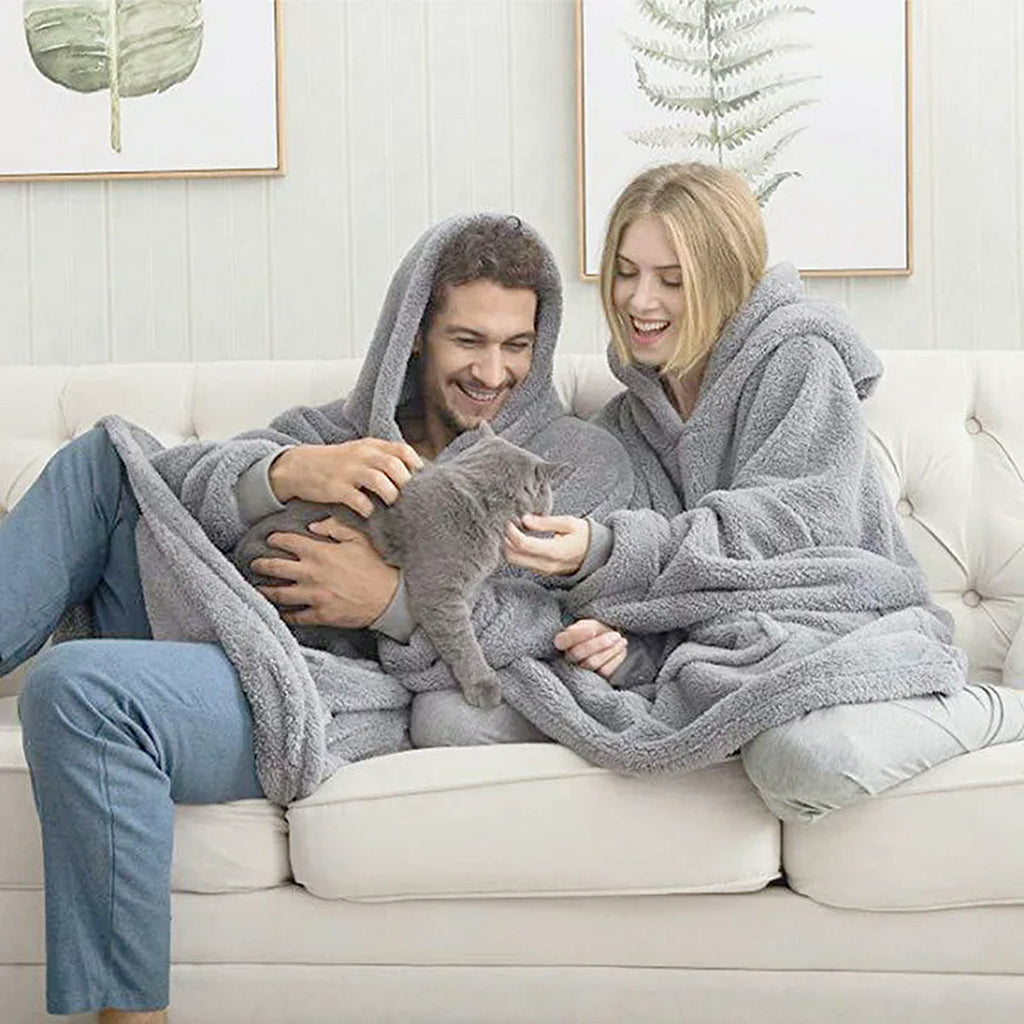 Couple sur un canapé avec un chat, tous deux en sweat plaid sherpa gris chiné