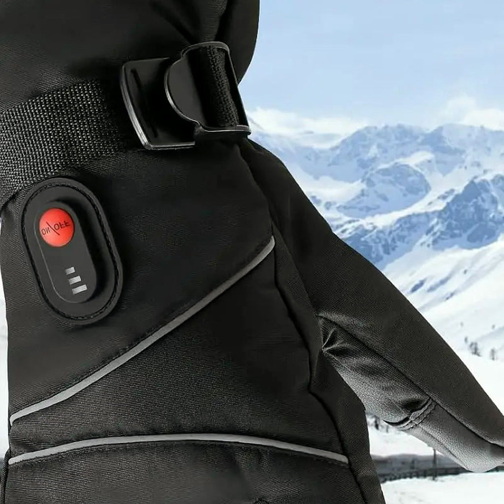 Gant de ski chauffant porté sur la neige, bouton de chaleur et sangle de poignet