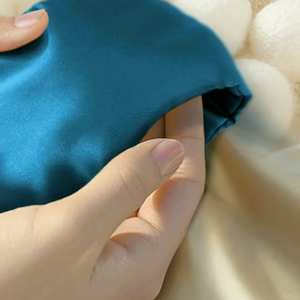 Le masque en soie de mûrier bleu canard tenu en main