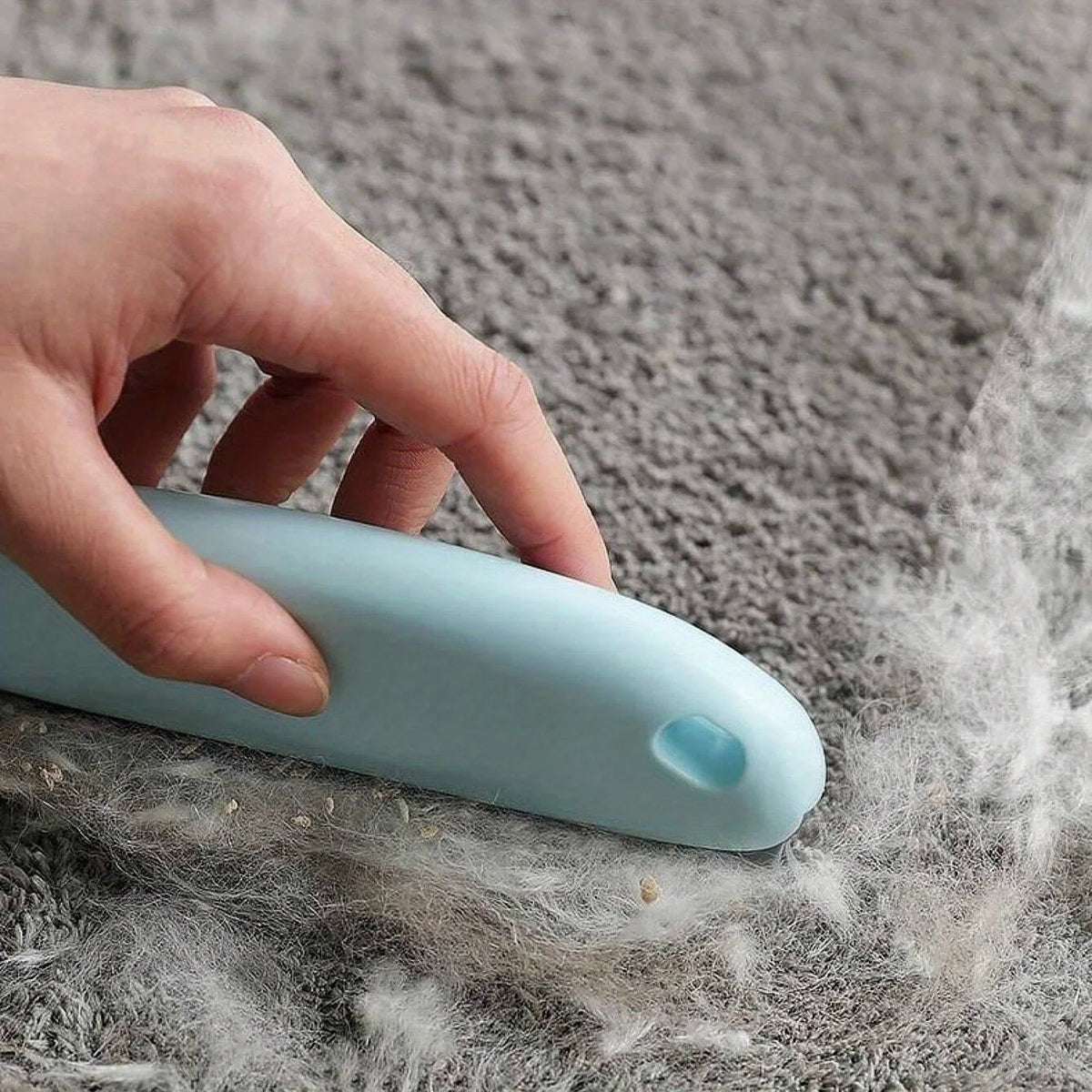 Poils rassemblés en bourrelet sur un tapis gris
